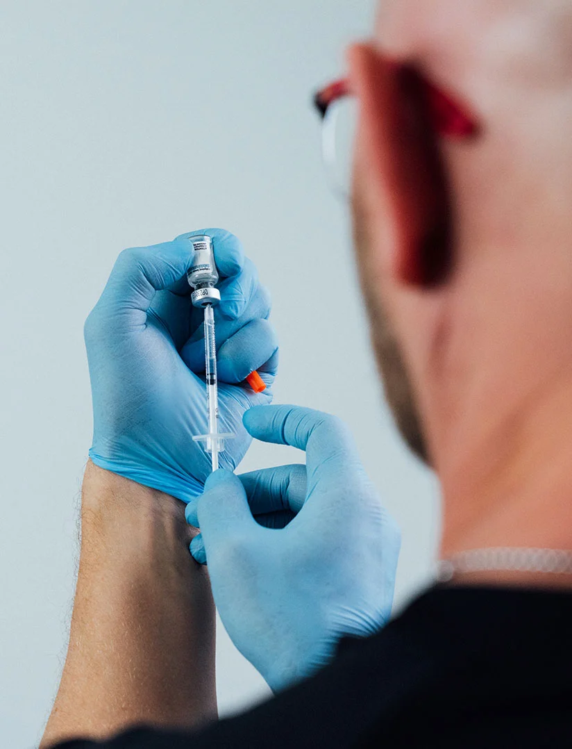 A close up shot of Dr. Craft filling a syringe from a small bottle. - Scrotox in Phoenix, AZ